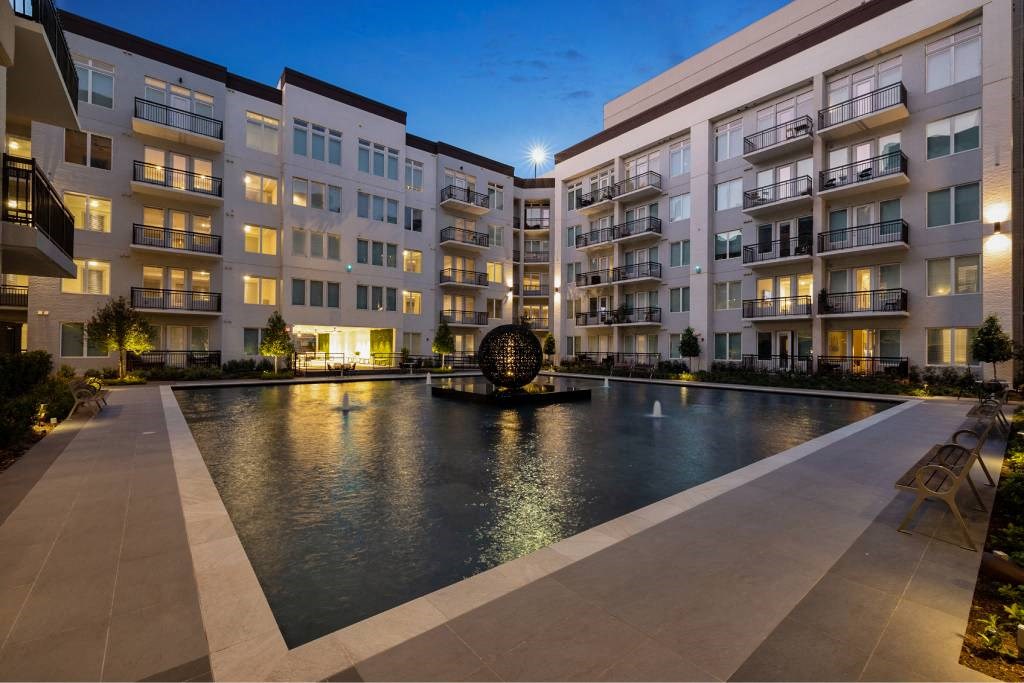 an apartment building with a pool in the middle of it