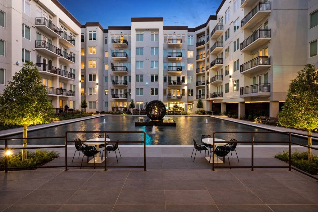 a large swimming pool in front of an apartment building