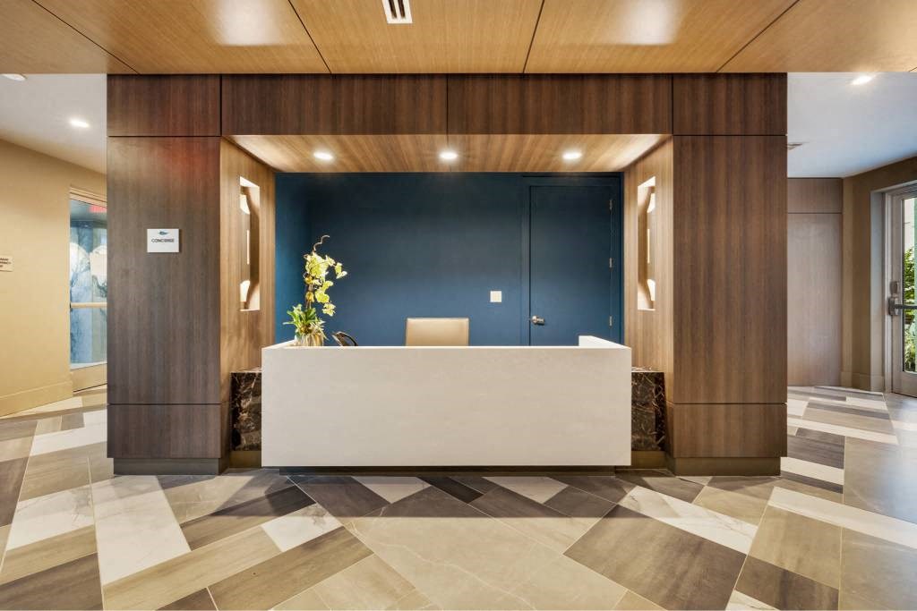 a large lobby with a white reception desk and wooden walls