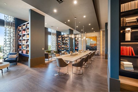 a dining room with a long table and chairs in a library