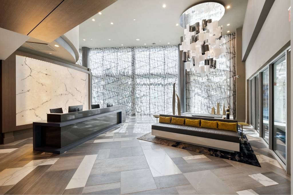 a lobby with a reception desk and a large glass door