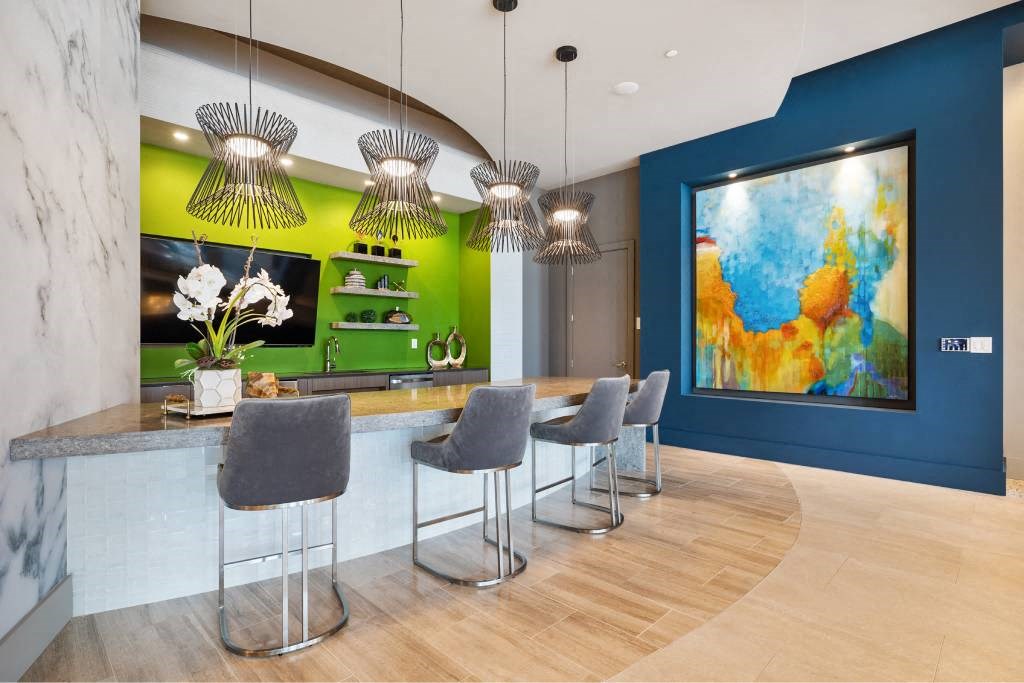 a kitchen with a bar and chairs and a painting on the wall