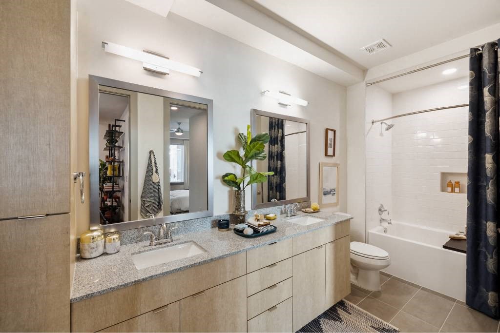 a bathroom with two sinks and a shower and a toilet
