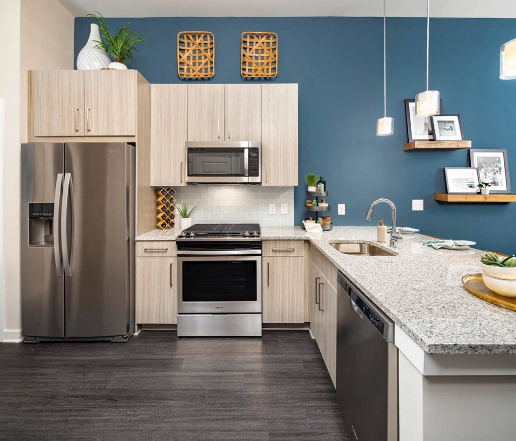 A modern kitchen with a stainless steel refrigerator and a microwave above the stove.
