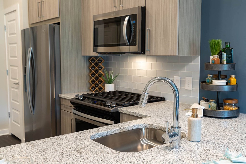 A kitchen with a granite countertop and stainless steel appliances.