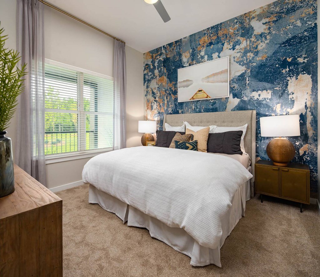 a bedroom with a bed and a blue and white wallpaper