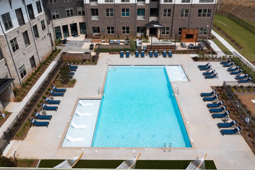 an aerial view of a swimming pool in front of an apartment building