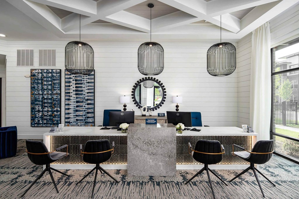 a large desk with chairs and a mirror in a room with white walls