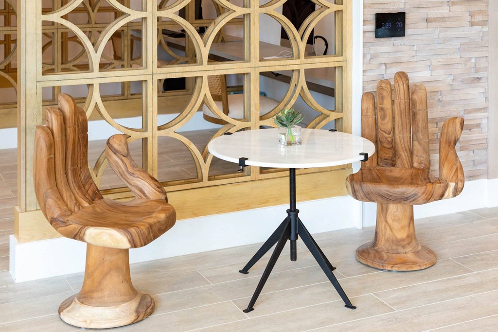 A wooden chair with a unique design is placed in front of a wooden shelf.
