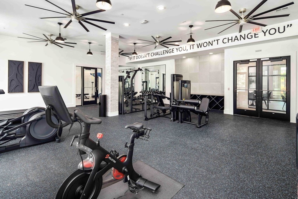 a home gym with exercise equipment and a sign that says weight change you