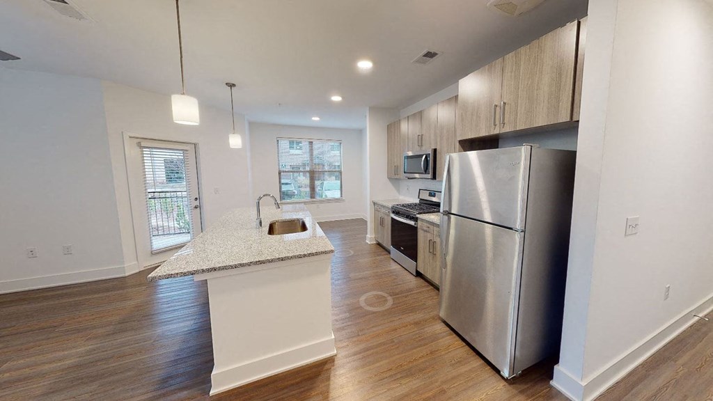 A kitchen with a sink and a refrigerator.
