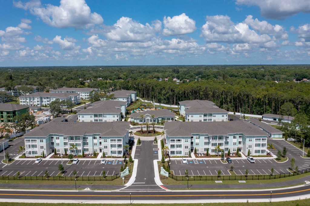 an aerial view of an apartment complex with roads and trees