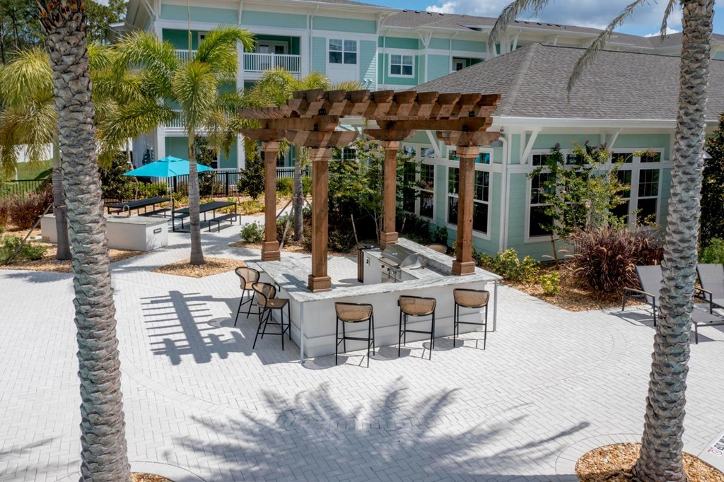 a patio with a table and chairs in front of a house