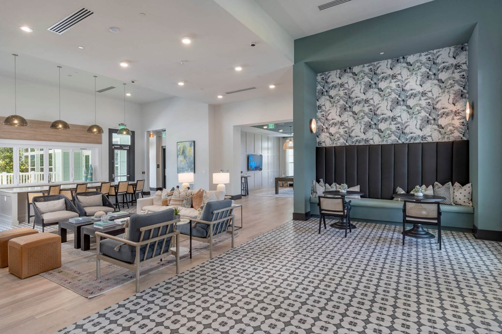 a lobby with couches chairs and tables and a large wall with a mural