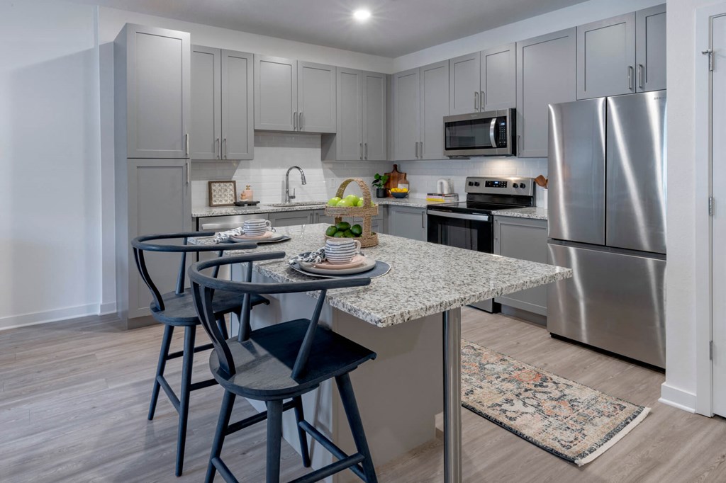 a kitchen with stainless steel appliances and an island with stools