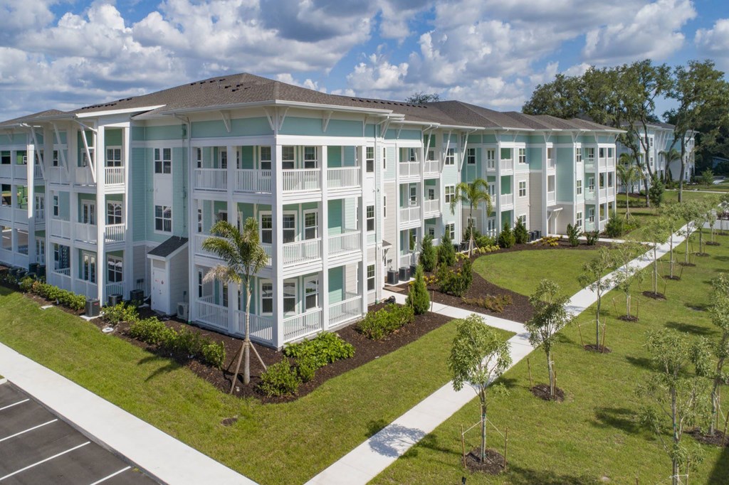 an aerial view of an apartment building with grass and trees