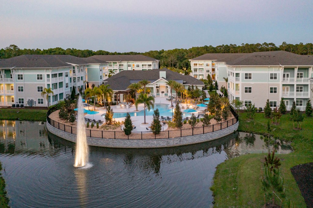 an aerial view of a swimming pool with a fountain in the middle of the water