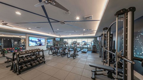 a fitness room with bikes and weights in it