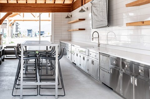 a kitchen with stainless steel appliances and a table and chairs