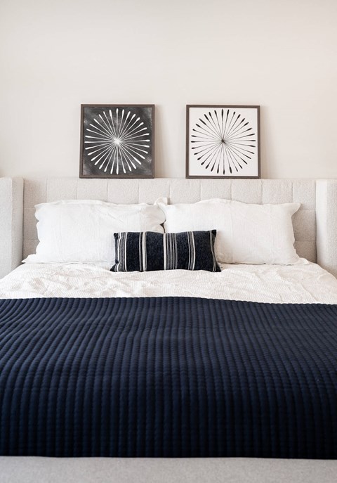 A cozy comfortable bed in a spacious bedroom