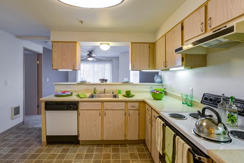 a kitchen with wooden cabinets and a stove and sink at Vista Ridge, Issaquah, WA