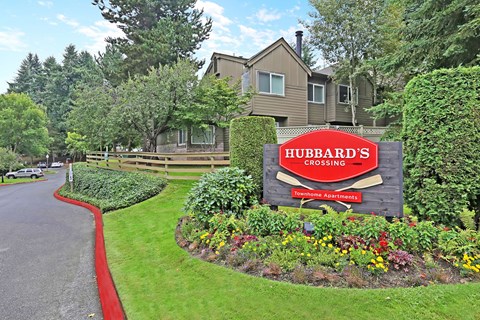 Community entrance sign with seasonal flower garden at Hubbard's Crossing Apartments, Kirkland
