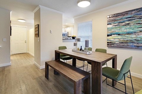 Dining area with wood table and green chairs at Hidden River Townhomes Apartments, Kirkland, WA