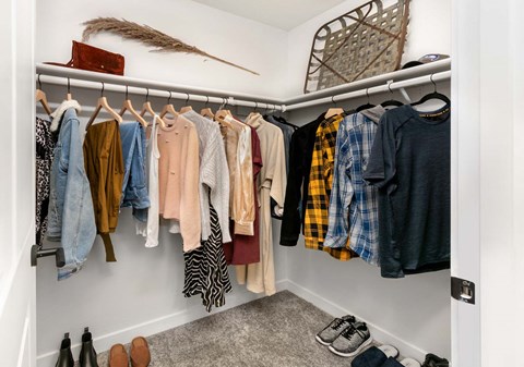 a closet with a rack of clothes and shoes at Scout, Kirkland
