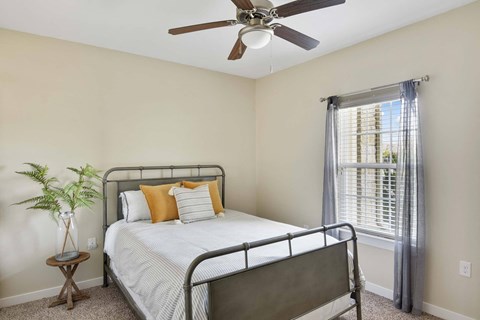 a bedroom with a bed and a ceiling fan