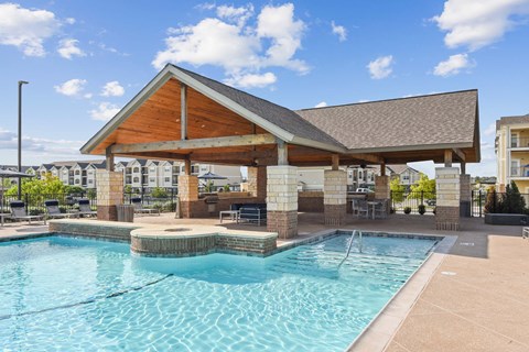 a resort style swimming pool with a covered pavilion next to a resortstyle pool