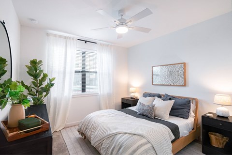 a bedroom with a bed and a ceiling fan