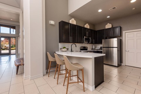 a kitchen with black cabinets and a white counter top