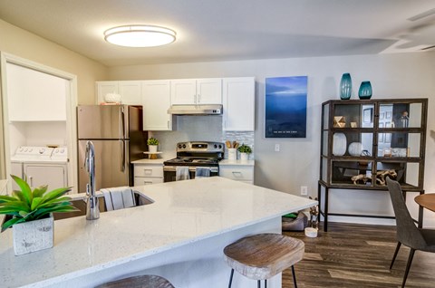 a kitchen with an island and a stainless steel refrigerator
