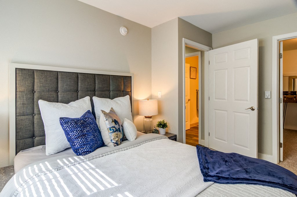 a bedroom with a large bed and a door to a bathroom