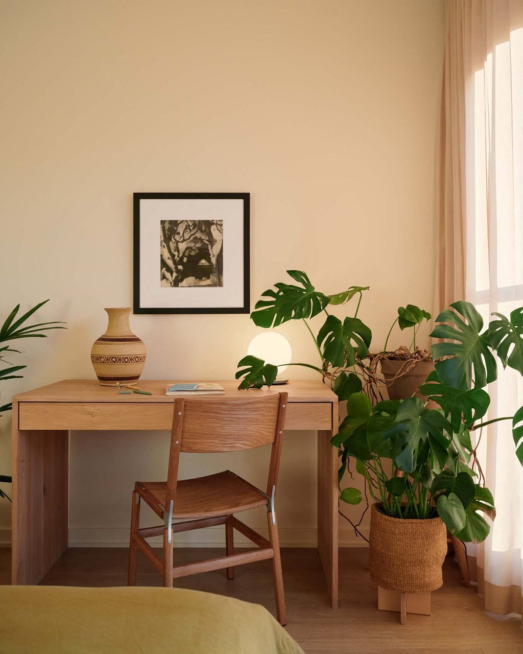a desk with a chair and a plant in a room