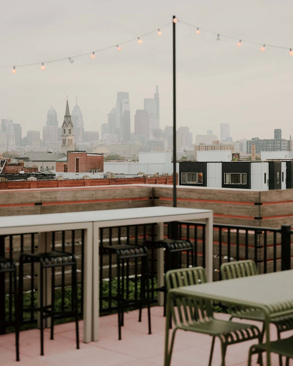 a view of the skyline from a rooftop restaurant with tables and chairs