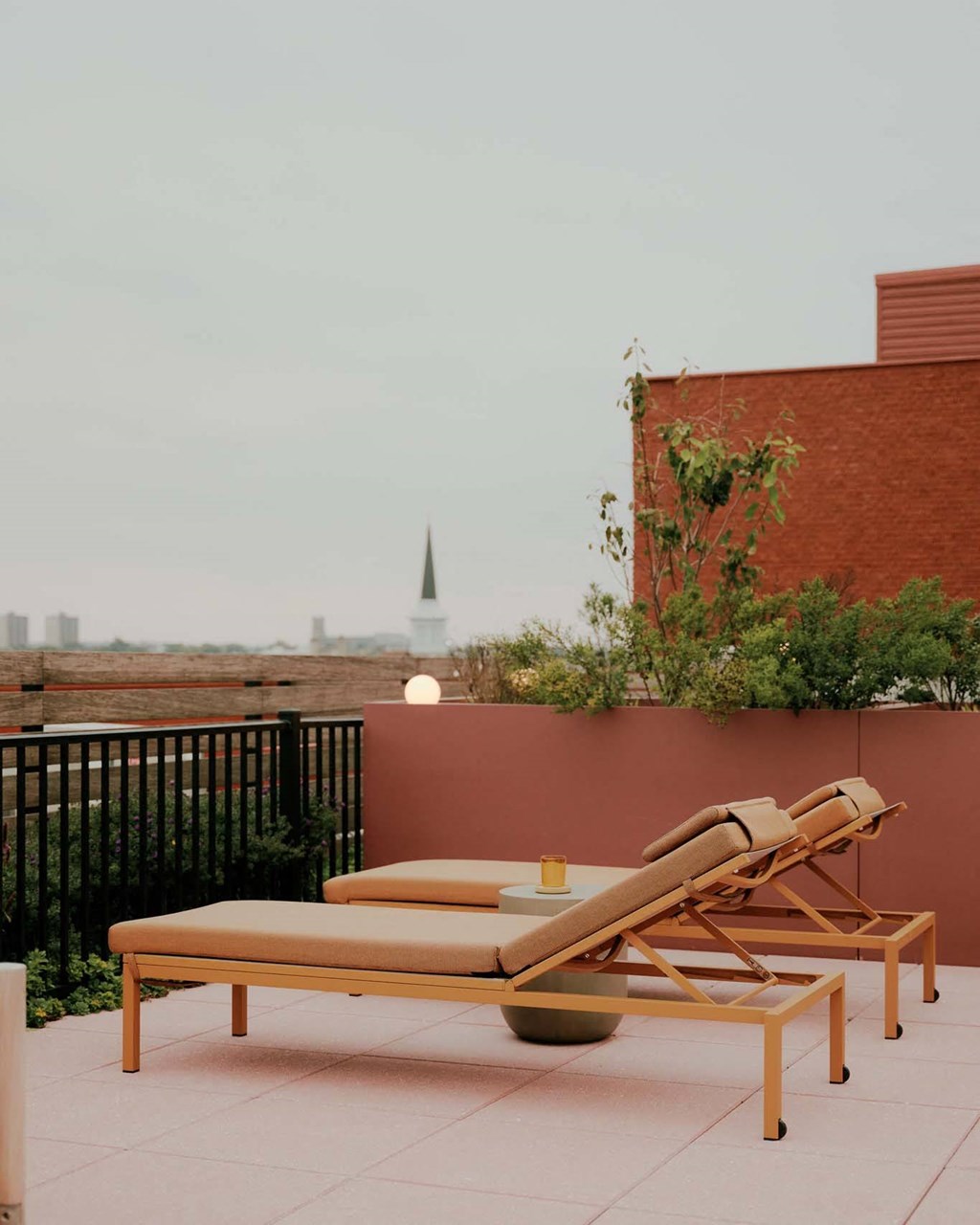 a rooftop terrace with lounge chairs and a table