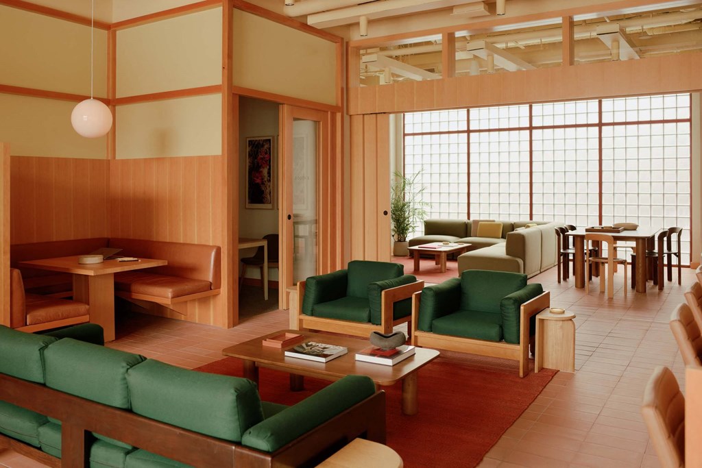 a living room with green couches and chairs and a table