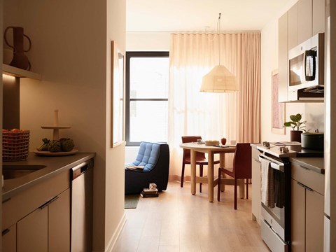 A kitchen with a blue chair and a table with chairs.