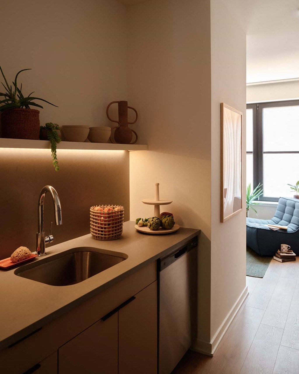a kitchen with a sink and a living room with a couch
