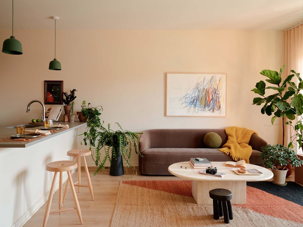 a living room with a couch and a kitchen with a counter