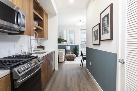 A modern kitchen with a black stove top oven and wooden cabinets.