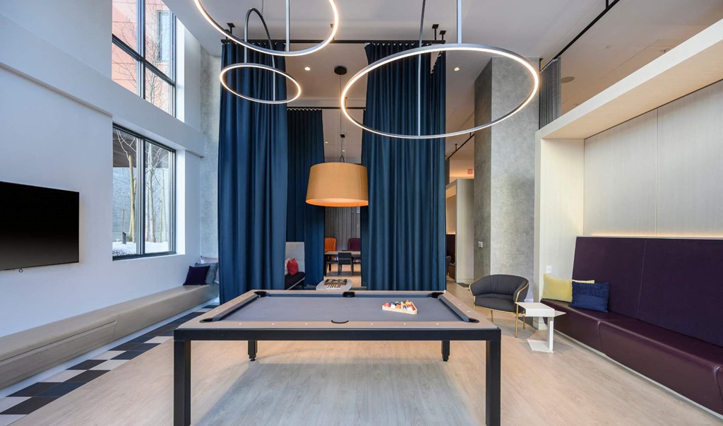 a pool table in a living room with a blue curtain