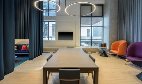 a conference room with a table and chairs and a television