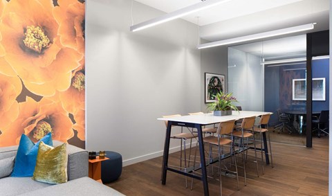 a dining room with a white table and chairs and a large wall mural