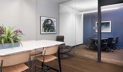 a conference room with a table and chairs and a painting on the wall