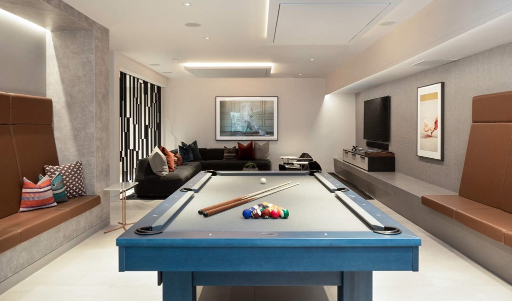 a games room with a pool table and a television