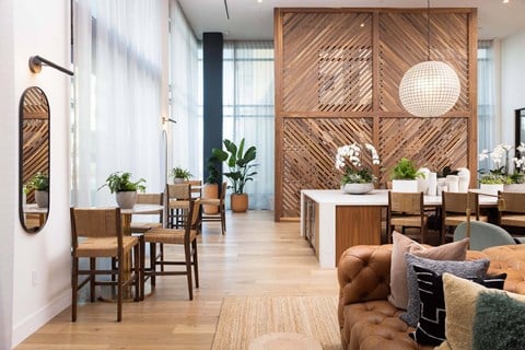 a living room with a couch and chairs and a dining room with tables