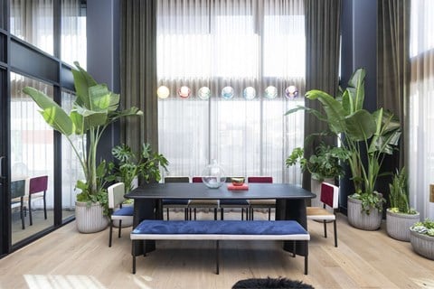 a dining room with a table and chairs and potted plants