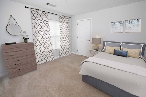 A bedroom with a large bed and a dresser with a mirror.